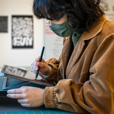 A student draws on a tablet