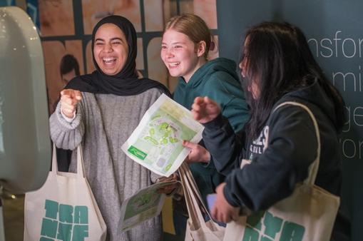 A group of three students laughing